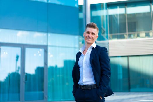 Business. Businessman Standing City Street Office Building Handsome Caucasian Male Business Person Portrait Corporative Building Background Successful Young Adult Manager Hands in pocket