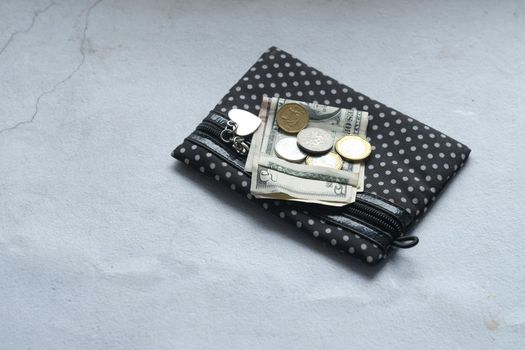 close up of wallet, cash and coins on table .