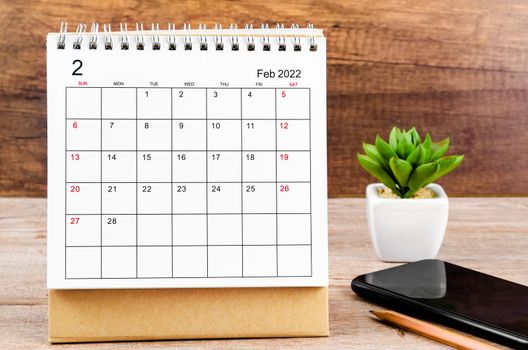 Februaryl desk calendar 2022 on wooden background.