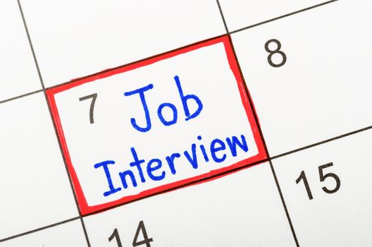 The words Job Interview written in calendar to remind you an important appointment.