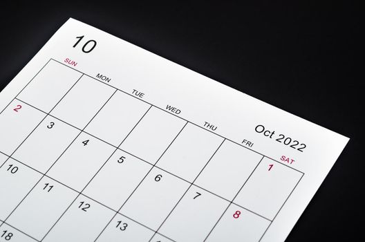 Close up October 2022 calendar sheet on black background.