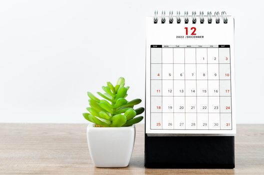 December 2022 desk calendar on wooden table.