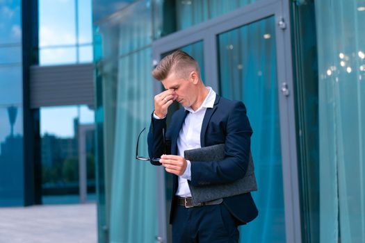 Business. Businessman Glasses With Folder Standing Office Building Entrance Worries Crisis Cry Rubs Eyes Caucasian Male Business Person City Corporative Building Background Trouble Depression Bankrupt