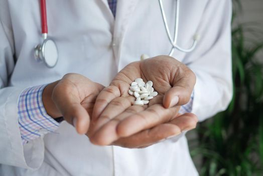 doctor holding medical pill on palm of hand .