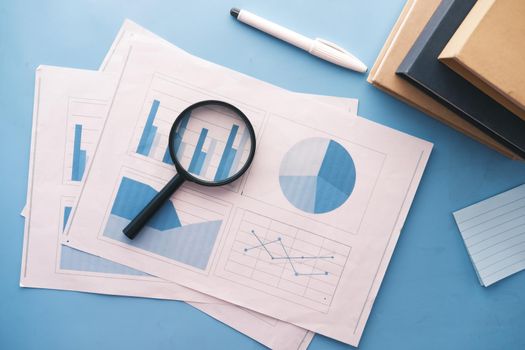 financial graph, calculator and notepad on table.