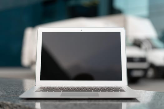 Open Laptop Black Screen With Office Building And Truck On Background Shipping Area Logistics Concept Delivering Vechicle Transportation Service