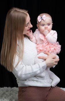 Mom holds her little daughter in her arms. Motherhood.