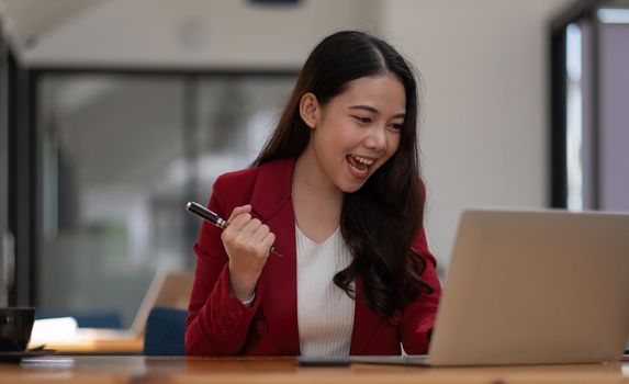 Portrait of success businesswoman enjoy success with laptop on work desk. Authentic shot joyful woman got jackpot, Surprised and celebrating her victory.