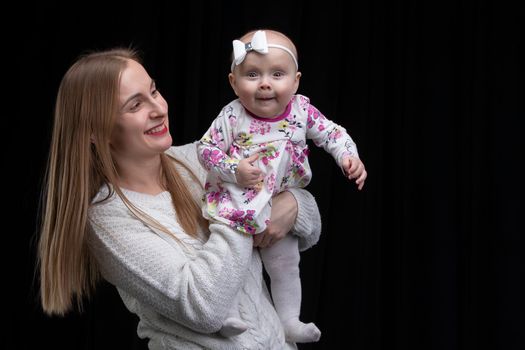 MomMom holds a little happy daughter in her arms.