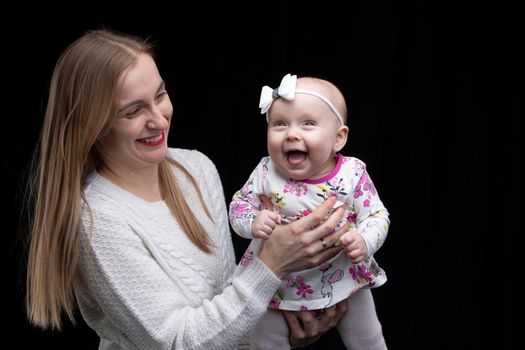 MomMom holds a little happy daughter in her arms.