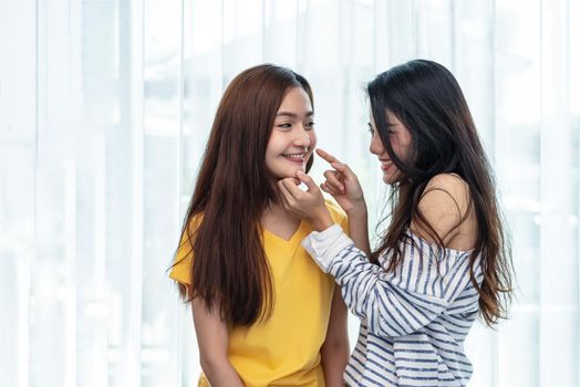 Two Asian women touching chin and playing with together. People and lifestyle concept. LGBT pride theme.