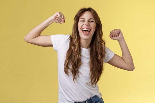 Girl thanks invitation awesome party having fun go wild raise hands up relaxed loose dancing lip sync cool music enjoying moment wear white t-shirt casual outfit celebrating yellow background. Lifestyle.