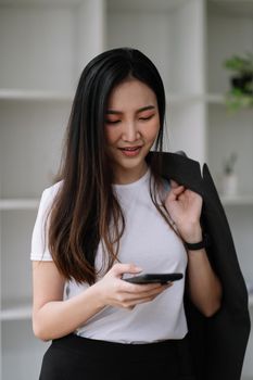 Cropped shot of asian woman using smart phone at home for messaging or browsing social network.