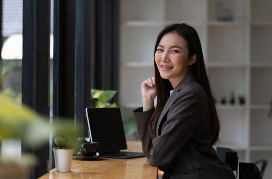 Portrait of smiling beautiful business asian woman working in modern office desk using tablet laptop computer, Business people employee freelance online marketing e-commerce telemarketing concept.