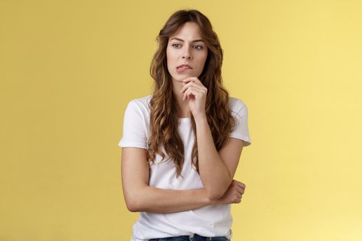 Need think what do how solve situation. Perplexed focused serious-looking thoughtful woman pouting touch lip look away pondering deep thinking standing yellow background hesitant. Copy space