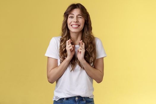 Excited happy cheerful optimistic girl peeking nervously awaiting results look one eye camera hopeful smiling broadly cross fingers good luck intense praying dream come true fulfillment wish. Lifestyle.