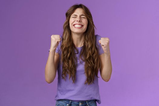 Yes I did it. Relieved happy triumphing joyful girl pump fists celebrating excellent achievement raise head up close eyes thank god winning first prize stand purple background happy.