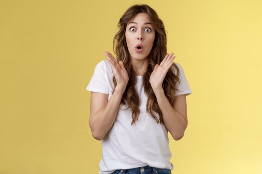 Shocked impressed surprised girl learn interesting pleasant good news clap hands open mouth fold lips wow gasping stare intrigued enthusiastic reaction awesome performance yellow background.