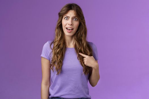 Accused frustrated upset shocked girl ambushed strange choice accusations pointing herself offended complaining frowning stand questioned displeased unfair decision purple background.