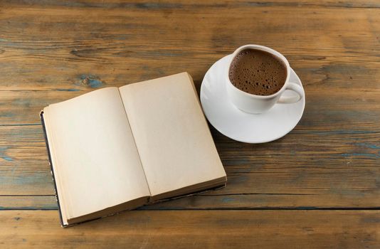 top view image of open book with blank pages next to cup of coffee on wooden table. ready for adding text or mockup