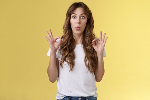 Wow was perfect excellent performance awesome. Impressed happy girl admire amazing friend effort show okay ok approval gesture like great idea folding lips temptation amazed yellow background.