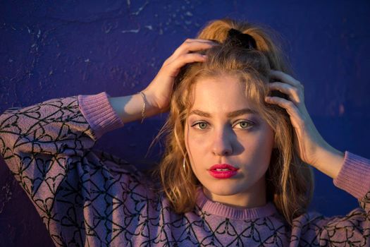 Portrait of a beautiful green-eyed girl on a purple background.