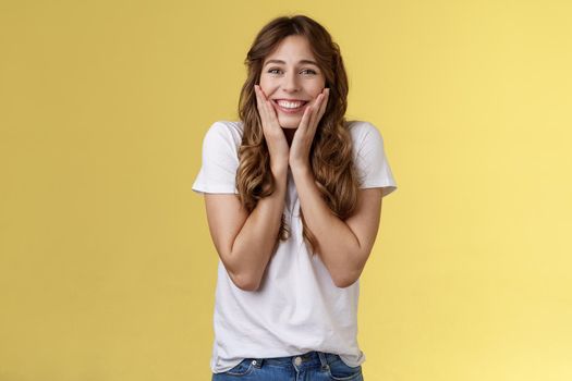 Cheerful happy upbeat young girl receive inredible opportunity study abroad student cheering celebrating stunning news touch cheeks blushing joy happiness smiling broadly yellow background.