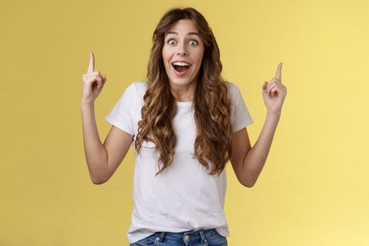 Happy enthusiastic impressed lively joyful girlfriend reacting astonished surprised excellent amusing promo gift pointing up index finger look admiration joy drop jaw fascinated temptation.