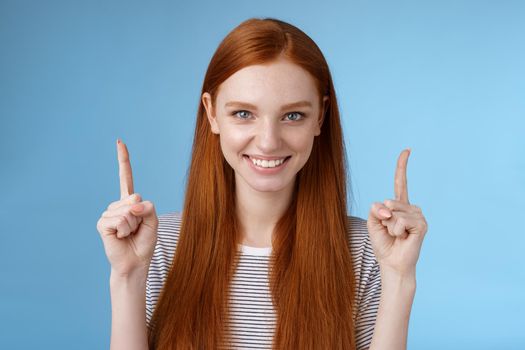 Lifestyle. Determined good-looking redhead female student enter college final decision pointing up index fingers raised confidently smiling white teeth look camera assertive giving recommendation what choose.