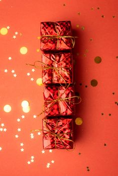 Red Christmas gifts and Christmas trees on a red background. An article about the New year and Christmas. The choice of gifts. A red gift . New Year's background