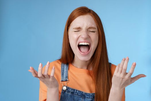 Lifestyle. Pissed outraged moody redhead girl shouting complaining angry standing bothered screaming out loud close eyes yelling loudly raising hands sideways dismay full disbelief feel cheated painful betrayal.