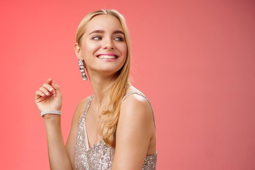 Elegant glamour gorgeous young rich blond woman attend charity party in stylish silver glittering dress accessorize turning right smiling greeting familiar person grinning joyfully, red background.