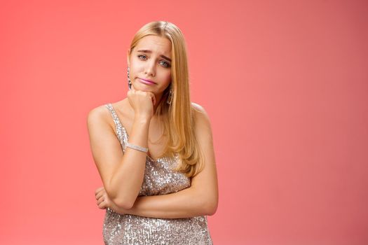 Bored uninterested careless attractive elegant young glamour blond woman lean head smirking indifferent feel boredom reluctant hear boring uninteresting story standing annoyed red background.