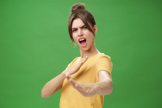 Not mess with this girl. Portrait of funny and emotive charismatic young woman standing in martial arts pose, showing fighting skills yelling kiya, open mouth frowning making karate movements.