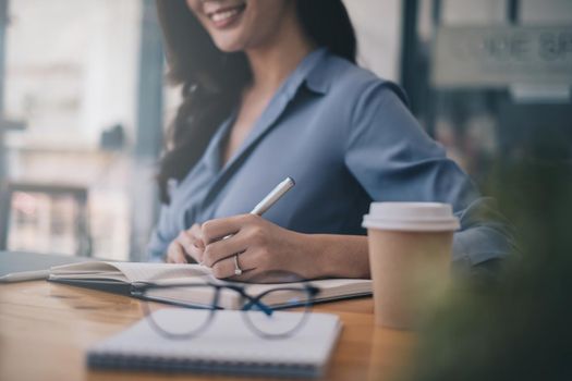 Portrait of cheerful asian woman with casual life on desk in home office. Concept of young business people working at home