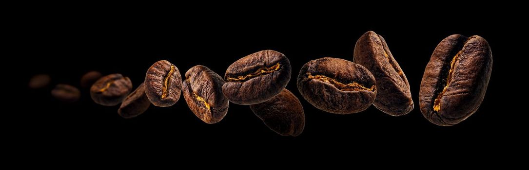 Coffee beans levitate on a black background.