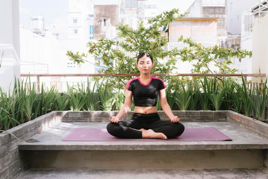 Woman on a yoga mat to relax outdoor.