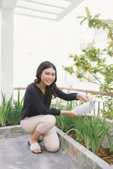 Beautiful young woman gardening outside in summer nature