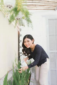 Beautiful young woman gardening outside in summer nature