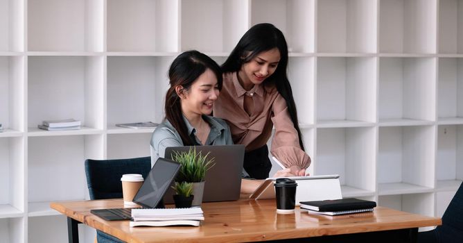 Group of asian young business people brainstorming at a meeting starting a new business. People working together with laptop computer.