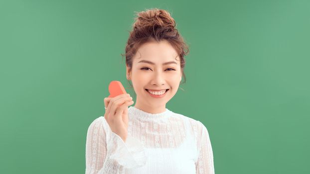 woman holding heart paper valentites card in green background