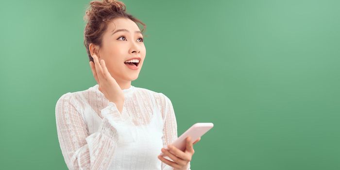 Photo of funny lady hold telephone hands look side empty space interested isolated green color background