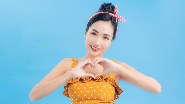 Beautiful woman forming a heart with her hands