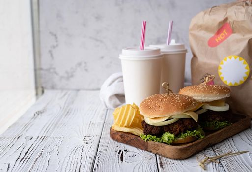 Fat unhealthy food close-up. Set of homemade burgers, chips and drink