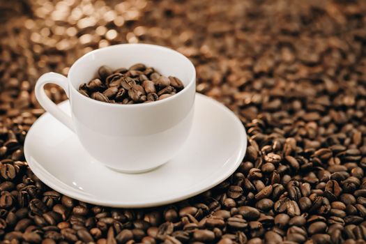 Roasted coffee beans with cup on beans background
