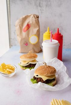 Fat unhealthy food close-up. Set of homemade burgers, chips and drink