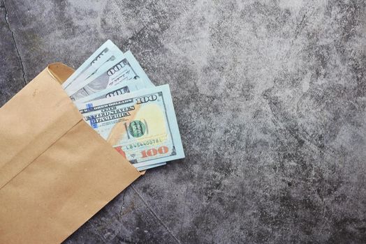 Close up of cash and coins in a envelope on table .