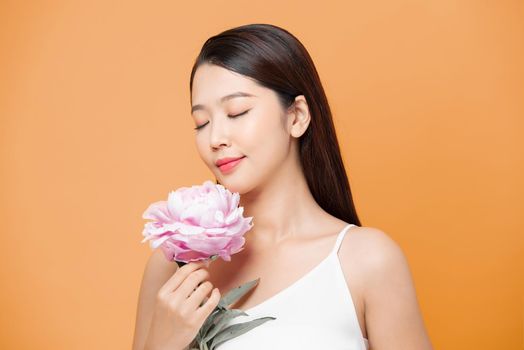 woman holding peony bouquet over yellow