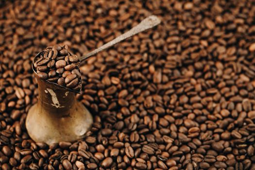 Turkish Coffee Pot and Coffee grains are scattered on the wooden surface