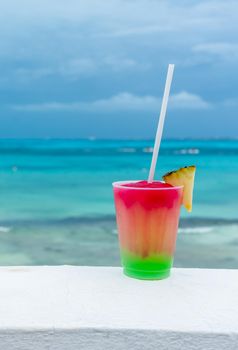 Cocktail with caribbean sea on background. Concept of beautiful vacation